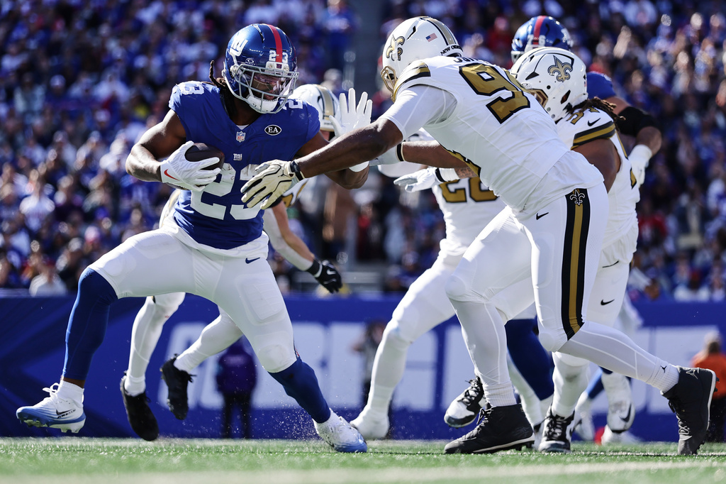 New York Giants running back Najee Harris (23) defends against New Orleans Saints linebacker Cameron Jordan (94) during the first half of an NFL football game in East Rutherford, N.J., Sunday, Oct. 18, 2026. (AP Photo/Adam Hunger)