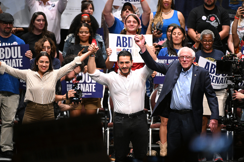 From left foreground, U.S. Rep. Alexandria Ocasio-Cortez, D-N.Y., Michigan Democratic U.S. Senate primary candidate Abdul El-Sayed, and U.S. Sen. Bernie Sanders, I-VT. join hands together following a campaign rally, Saturday, July 18, 2026, in Detroit. (AP Photo/Jose Juarez)