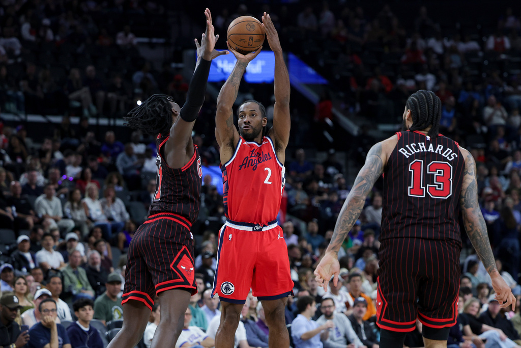 Los Angeles Clippers forward Kawhi Leonard, center, shoots against Chicago Bulls forward Leonard Miller, left, and center Nick Richards, right, during the first half of an NBA basketball game Friday, March 13, 2026, in Inglewood, Calif. (AP Photo/Ryan Sun)