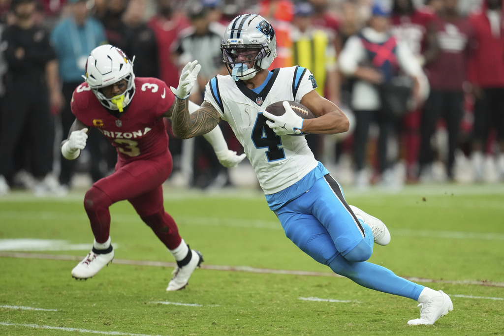 Carolina Panthers wide receiver Tetairoa McMillan (4) runs as Arizona Cardinals safety Budda Baker (3) pursues during the second half of an NFL football game, Sunday, Sept. 14, 2025, in Glendale, Ariz. (AP Photo/Rick Scuteri)