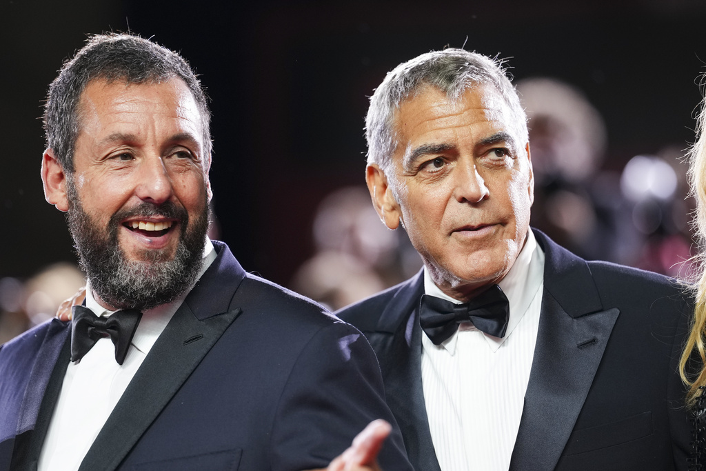 Adam Sandler, left, and George Clooney pose for photographers at the red carpet for the film 'Jay Kelly' during the 82nd edition of the Venice Film Festival in Venice, Italy, on Thursday, Aug. 28, 2025. (Photo by Scott A Garfitt/Invision/AP)