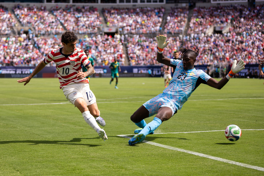 United States forward Christian Pulisic (10) shoots past Senegal forward Cherif Ndiaye (23) during the first half of an international friendly soccer match Sunday, May 31, 2026, in Charlotte, N.C. (AP Photo/Scott Kinser)