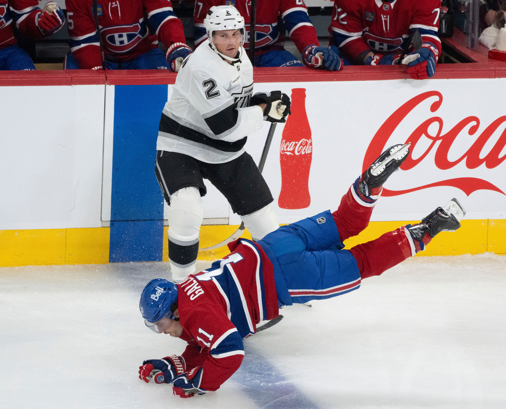 Montreal Canadiens' Brendan Gallagher (11) is tripped up in front of Los Angeles Kings' Brian Dumoulin (2) during the third period of an NHL hockey game, in Montreal, Tuesday, Nov. 11, 2025. (Christinne Muschi/The Canadian Press via AP)
