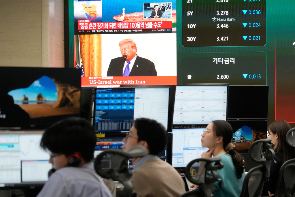 U.S. President Donald Trump is seen on a screen as traders work at the foreign exchange dealing room of the Hana Bank headquarters in Seoul, South Korea, Tuesday, March 3, 2026. (AP Photo/Ahn Young-joon)