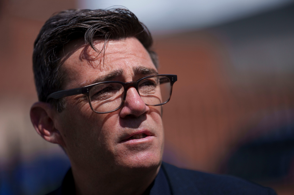 Andy Burnham speaks with police personnel during a campaign visit to the town of Ashton-in-Makerfield before the forthcoming Makerfield by-election, in Greater Manchester, England, Tuesday, June 9, 2026. (AP Photo/Jon Super)