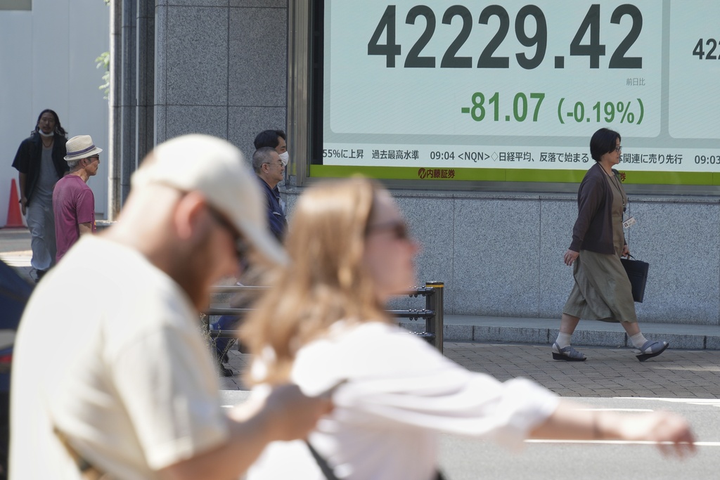 People walk in front of an electronic stock board showing Japan's Nikkei index at a securities firm Wednesday, Sept. 3, 2025, in Tokyo. (AP Photo/Eugene Hoshiko)