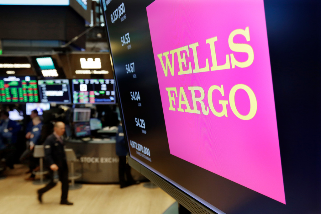 FILE- In this May 17, 2018, file photo the logo for Wells Fargo appears above a trading post on the floor of the New York Stock Exchange. (AP Photo/Richard Drew, File)