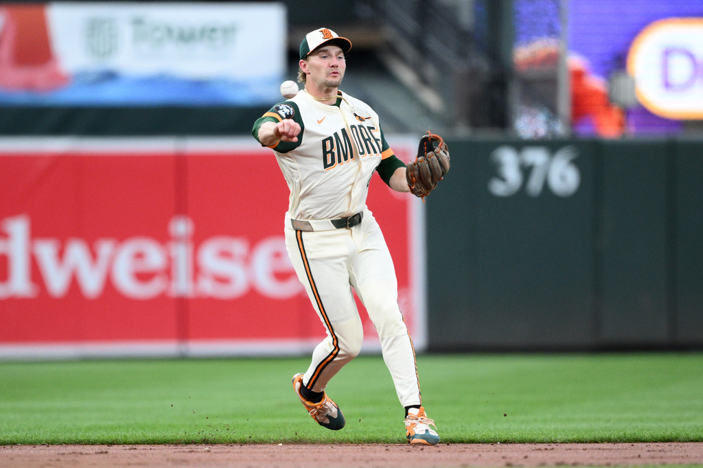 Baltimore Orioles shortstop Gunnar Henderson throws to first base but is unable to get Washington Nationals' Jacob Young who was safe on his throwing error during the third inning of a baseball game, Friday, June 26, 2026, in Baltimore. (AP Photo/Nick Wass)