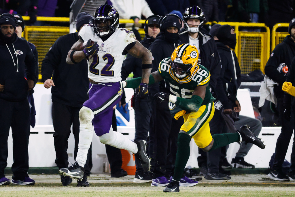 Baltimore Ravens running back Derrick Henry (22) runs the ball past Green Bay Packers linebacker Edgerrin Cooper (56) during the second half of an NFL football game, Saturday, Dec. 27, 2025, in Green Bay, Wis. (AP Photo/Mike Roemer)