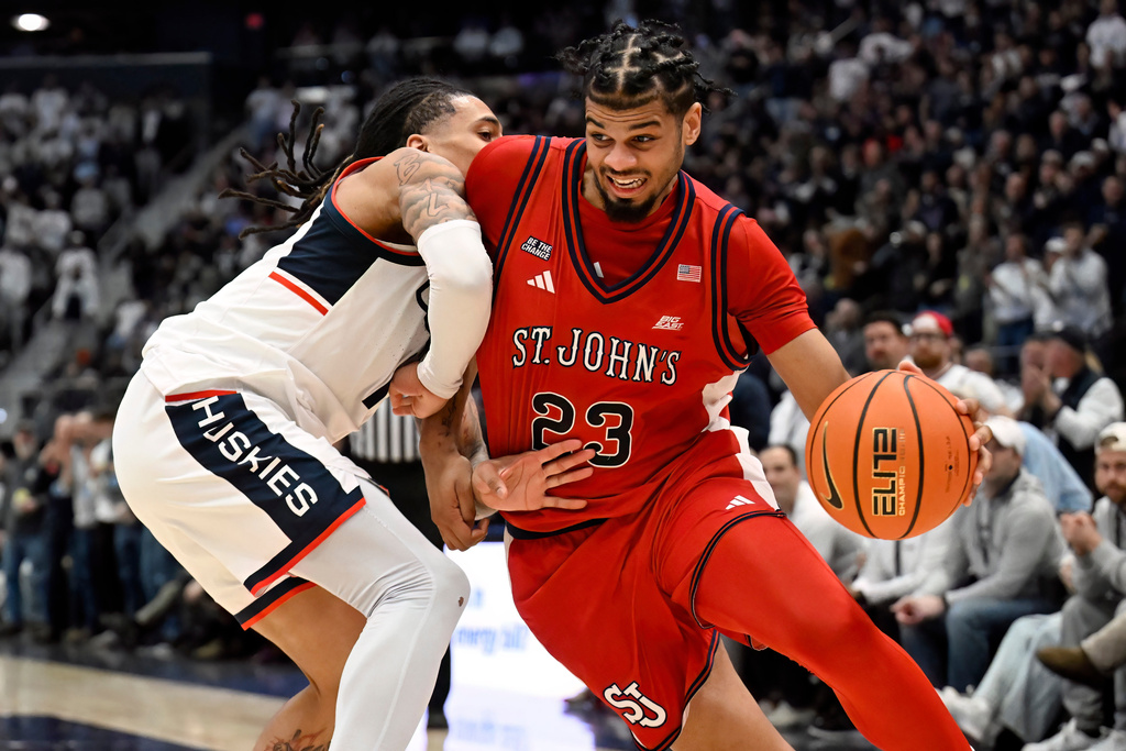 St. John's forward Bryce Hopkins (23) is guarded by UConn guard Solo Ball in the first half of an NCAA college basketball game, Wednesday, Feb. 25, 2026, in Hartford, Conn. (AP Photo/Jessica Hill)