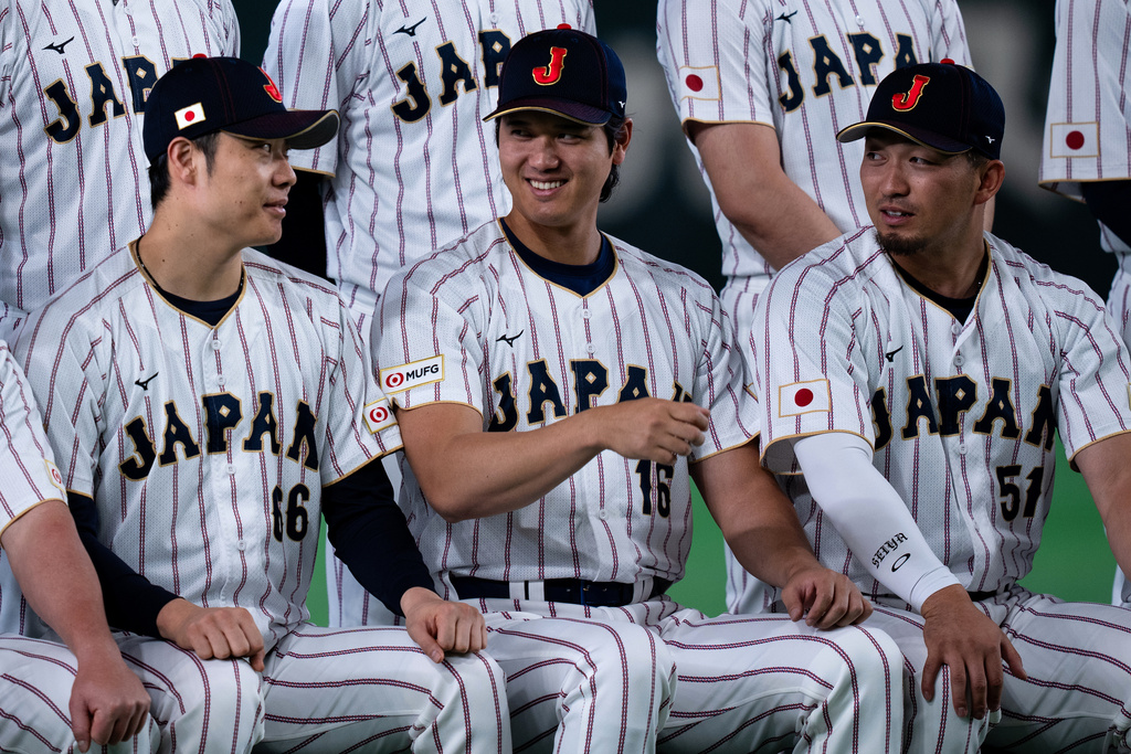Japan's Shohei Ohtani, center, smiles during a group photo session along with other team members before their practice session ahead of the World Baseball Classic games in Tokyo, Wednesday, March 4, 2026. (AP Photo/Louise Delmotte)