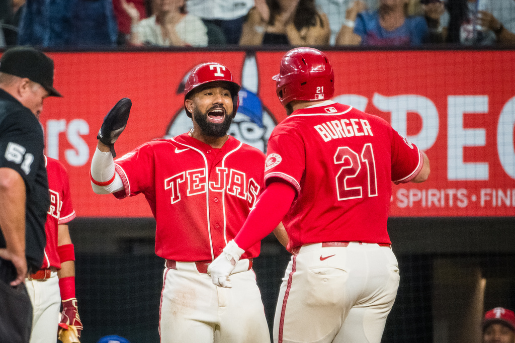 Texas Rangers' Jake Burger (21) is celebrates hitting a home run with Texas Rangers' Ezequiel Duran during the fourth inning of a baseball game against the Seattle Mariners, Friday, July 24, 2026, Arlington, Texas. (AP Photo/Jessica Tobias)