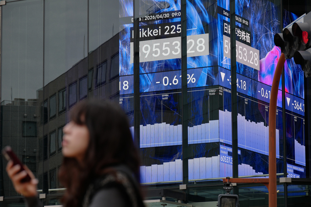 A person stands in front of an electronic stock board showing Japan's Nikkei index at a securities firm Thursday, April 30, 2026, in Tokyo. (AP Photo/Eugene Hoshiko)