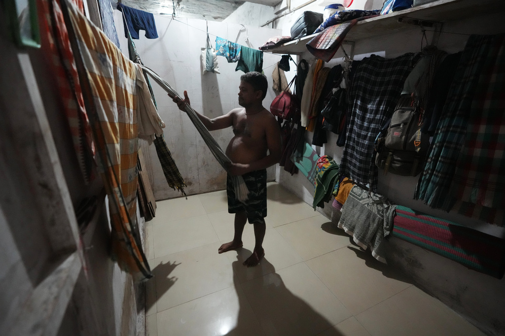 Power loom factory worker Sibaram Pradhan gets ready to take a bath after a day's work at his residential quarters in Surat, India, Wednesday, May 27, 2026. (AP Photo/Ajit Solanki)