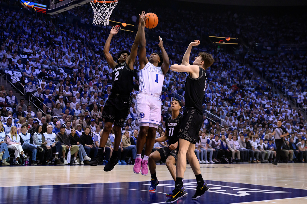 BYU guard Robert Wright III (1) goes to the basket for a layup guarded by Colorado guard Isaiah Johnson (2) during the first half of an NCAA college basketball game, Saturday, Feb. 14, 2026, in Provo, Utah. (AP Photo/Tyler Tate)