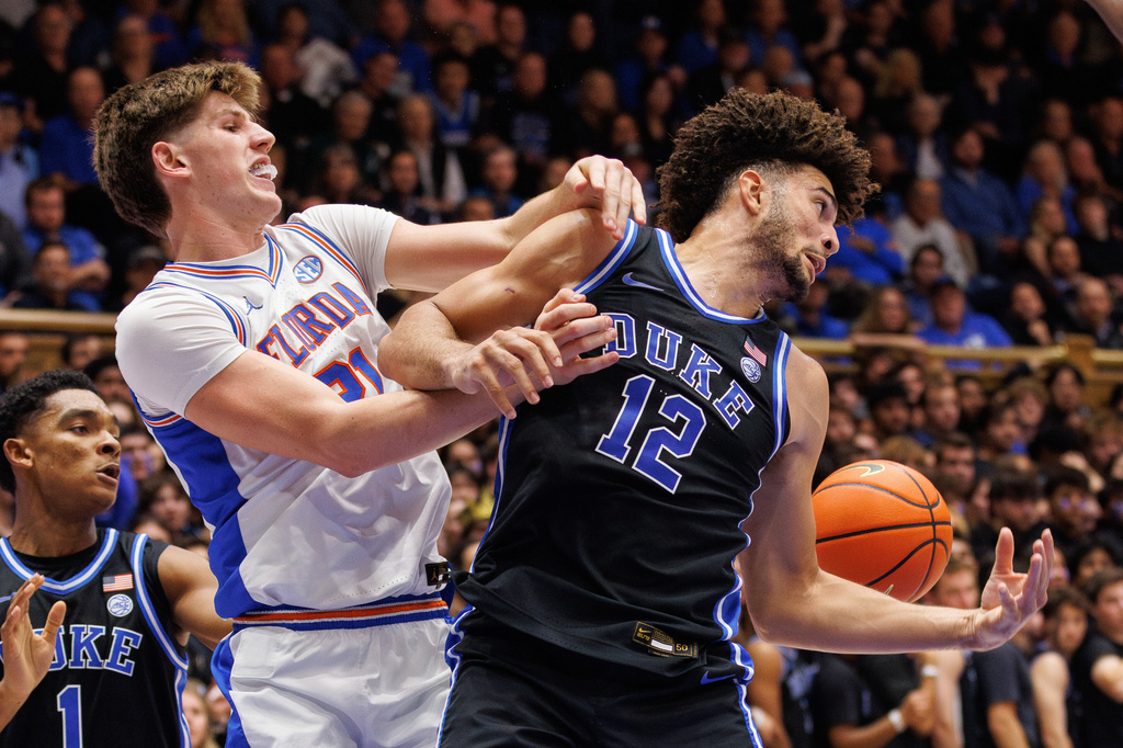 Duke's Cameron Boozer (12) and Floida's Alex Condon (21) battle for a loose ball during the first half of an NCAA college basketball game in Durham, N.C., Tuesday, Dec. 2, 2025. (AP Photo/Ben McKeown)