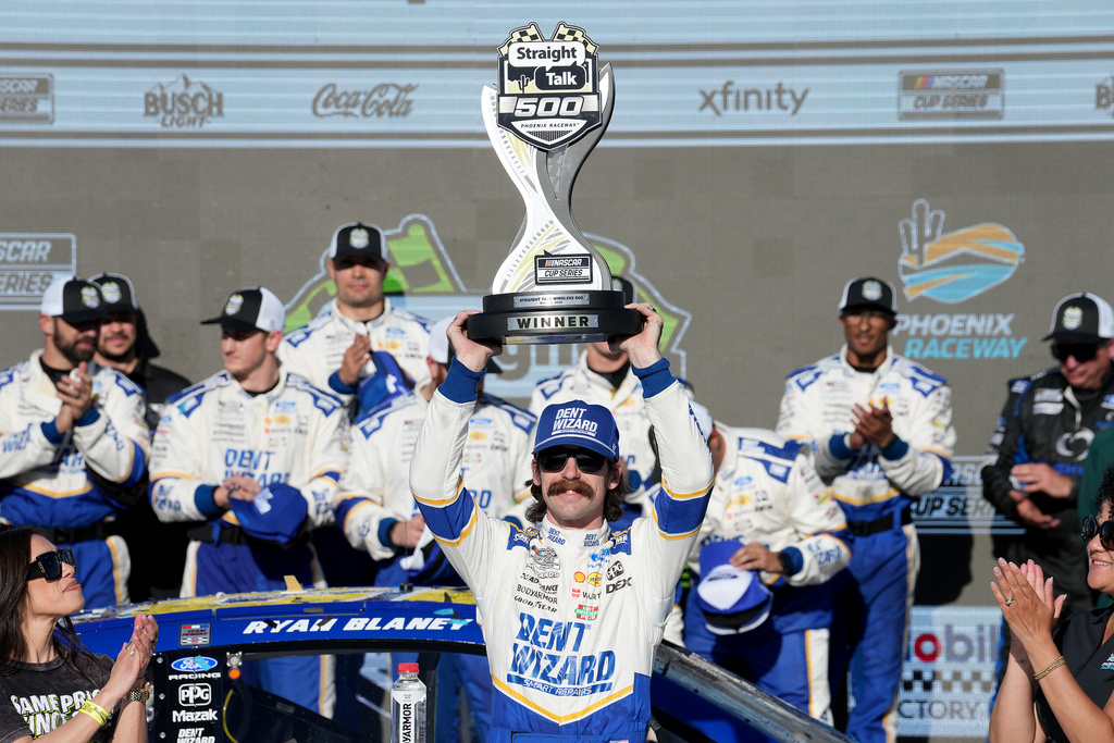 Ryan Blaney hoists the trophy in Victory Lane after winning a NASCAR Cup Series auto race at Phoenix Raceway, Sunday, March 8, 2026, in Avondale, Ariz. (AP Photo/Darryl Webb)