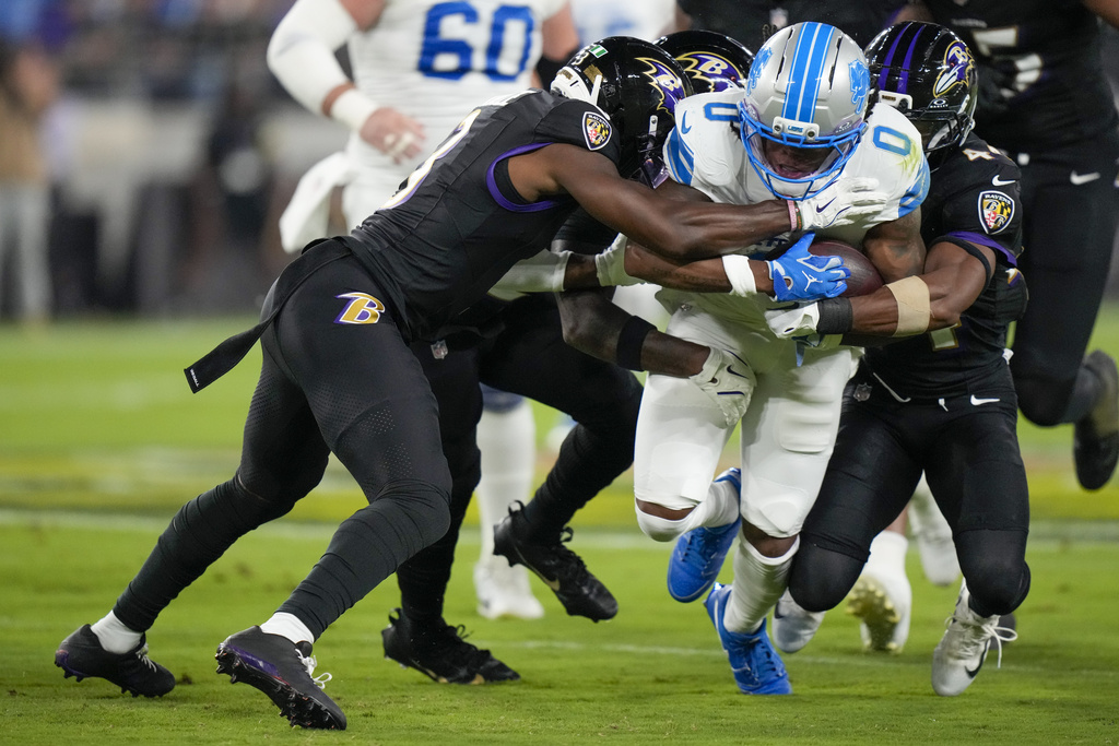 Detroit Lions running back Jahmyr Gibbs (0) is tackled by a host of Baltimore Ravens defenders during the first half of an NFL football game Monday, Sept. 22, 2025, in Baltimore. (AP Photo/Stephanie Scarbrough)