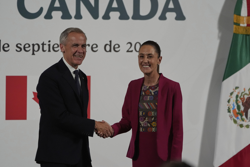 Canada's Prime Minister Mark Carney, left, and Mexico's President Claudia Sheinbaum shake hands after a joint press conference at the National Palace in Mexico City, Thursday, Sept. 18, 2025. (AP Photo/Fernando Llano)