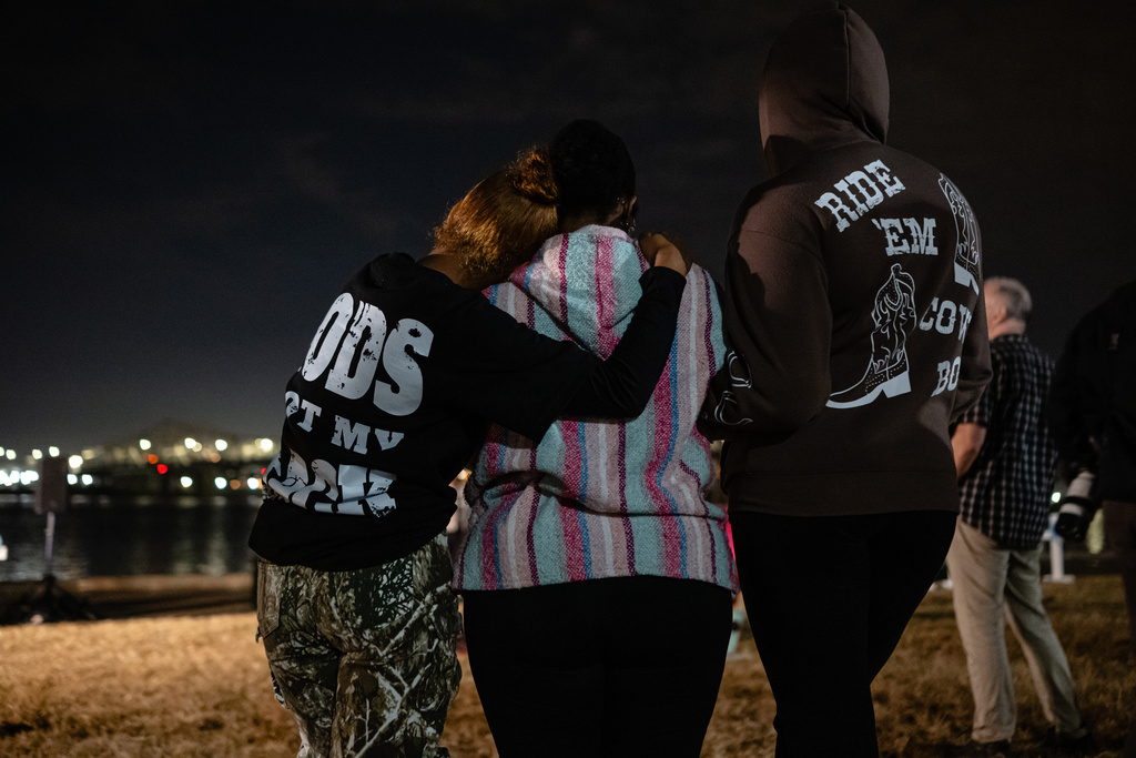 Community members embrace during a vigil for those killed and missing after a UPS plane crashed, at the Great Lawn, Friday, Nov. 7, 2025, in Louisville, Ky. (AP Photo/Jon Cherry)