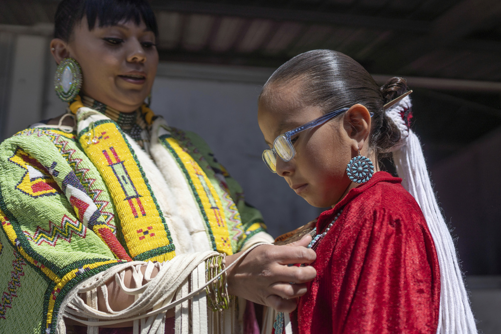 FILE - Shantal Sandoval, left, and her eight year-old daughter Chanel Yazzie, of To'hajiilee, N.M., prepare to participate in a horse parade at the 40th anniversary of the Gathering of Nations Pow Wow in Albuquerque, N.M., April 28, 2023. (AP Photo/Roberto E. Rosales, File)