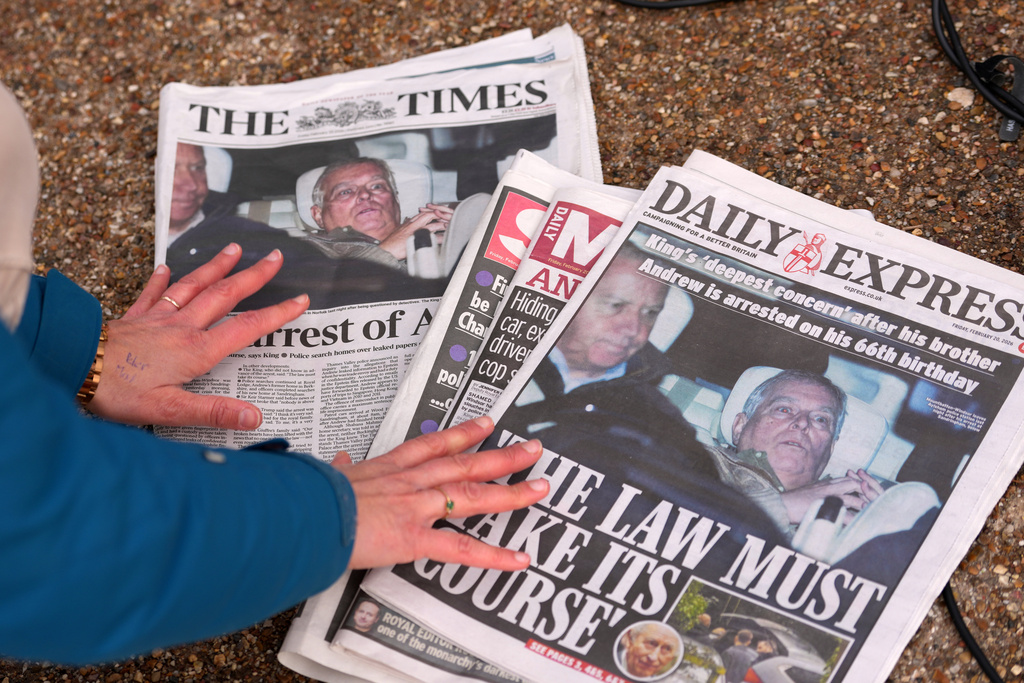A journalist looks at today's newspaper front pages in London, Friday, Feb. 20, 2026 after Andrew Mountbatten-Windsor was arrested and held for hours by British police on suspicion of misconduct in public office related to his links to Jeffrey Epstein.(AP Photo/Kin Cheung)
