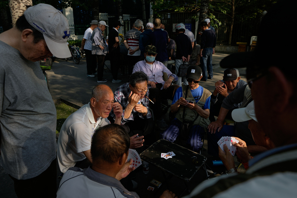 Residents play cards at a public park near a residential complex, in Beijing, Tuesday, May 12, 2026. (AP Photo/Andy Wong)