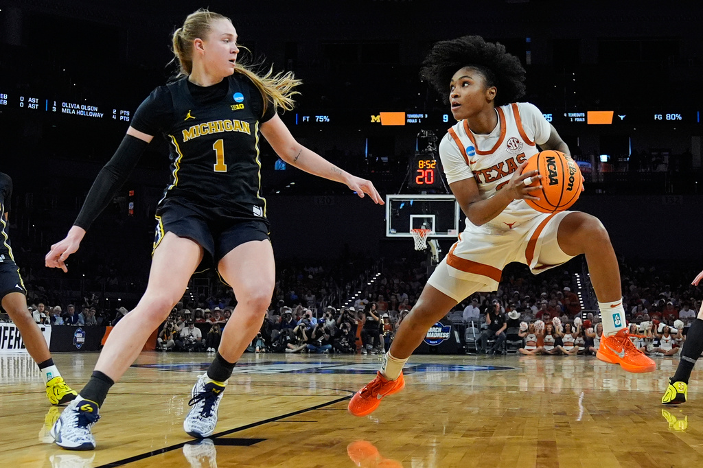 Texas guard Rori Harmon (3) steps back to shoot on Michigan guard Olivia Olson (1) during the first half in the Elite Eight of the NCAA college basketball tournament, Monday, March 30, 2026, in Fort Worth, Texas. (AP Photo/Tony Gutierrez)