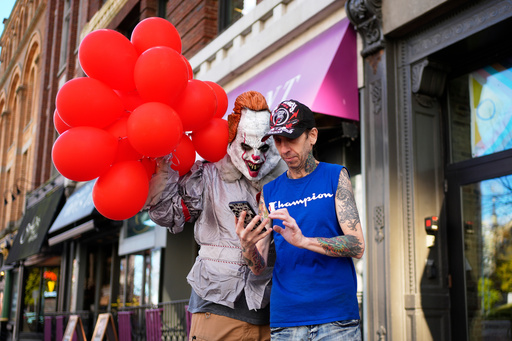 A man dressed as Pennywise, a character from a Steven King novel, checks to see how a selfie turned out with coffee shop worker Jeff Small, Friday, Oct. 31, 2025, in Portland, Maine. (AP Photo/Robert F. Bukaty) A man dressed as Pennywise, a character from a Steven King novel, checks to see how a selfie turned out with coffee shop worker Jeff Small, Friday, Oct. 31, 2025, in Portland, Maine. (AP Photo/Robert F. Bukaty)
