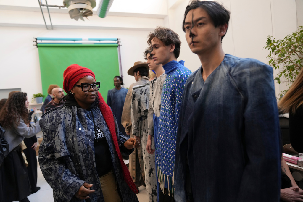 Afro Fashion Association founder Michelle Ngonmo prepares models in the backstage of the Victor-Hart Fall/Winter 2026-2027 Men's fashion show presented in Milan, Italy, Jan. 18, 2026. (AP Photo/Antonio Calanni)