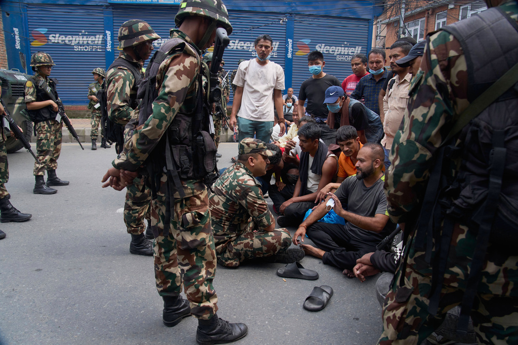 A Nepalese army personnel speaks to prisoners who escaped from Dilli Bazaar jail after being recaptured and refusing to return to prison in Kathmandu, Nepal, Wednesday, Sept. 10, 2025. (AP Photo/Niranjan Shrestha)