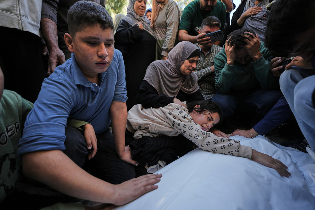 Dima Yassin mourns over the body of her mother, Dina Yassin, during the funeral of her parents, who were killed in an Israeli army strike on an apartment in Gaza City, Tuesday, Oct. 20, 2026. (AP Photo/Jehad Alshrafi)