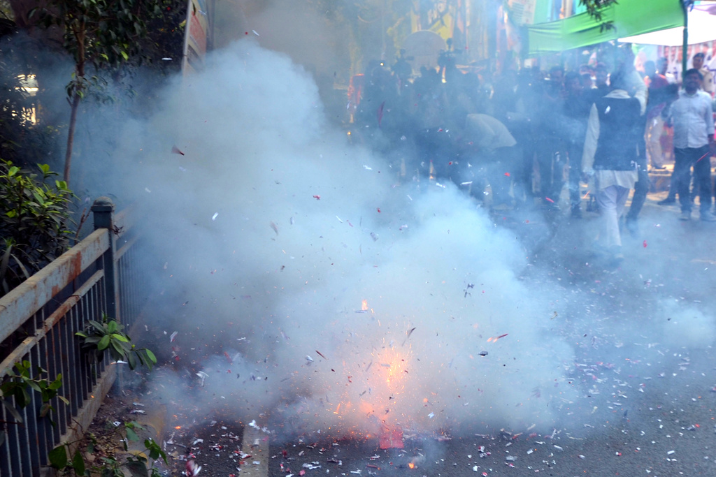 Supporters of Janata Dal (United) burn firecrackers as they celebrate the early leads in Bihar state election results in Patna, India, Friday, Nov.14, 2025. (AP Photo)