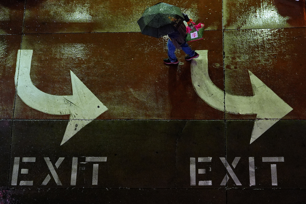 A man walks in the rain as a thunderstorm moves through the area Thursday, April 23, 2026, in Kansas City, Mo. (AP Photo/Charlie Riedel)