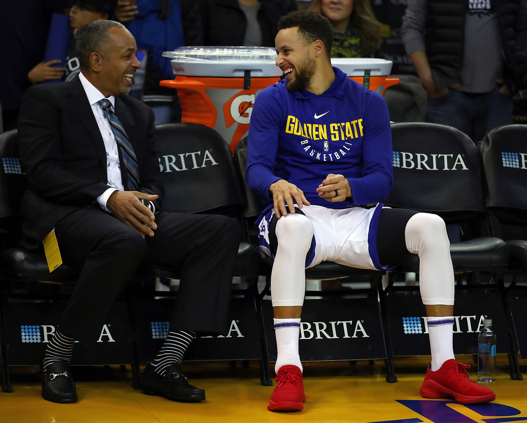 FILE - Golden State Warriors' Stephen Curry, right, laughs with his father, Dell Curry, prior to an NBA basketball game against the Charlotte Hornets on Friday, Dec. 29, 2017, in Oakland, Calif. (AP Photo/Ben Margot, File)
