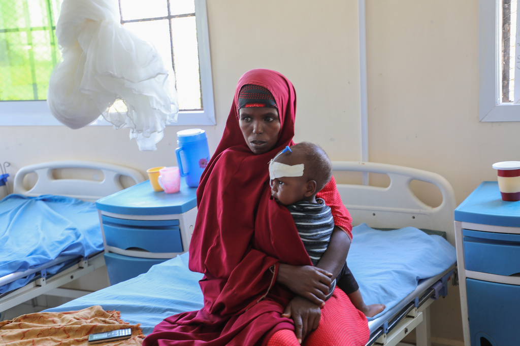 Isho Isak sits with her malnourished child at Dolow Referral Hospital in southern Somalia after being affected by drought, Wednesday, March 25, 2026 (AP Photo/Mohamed Sheikh Nor)