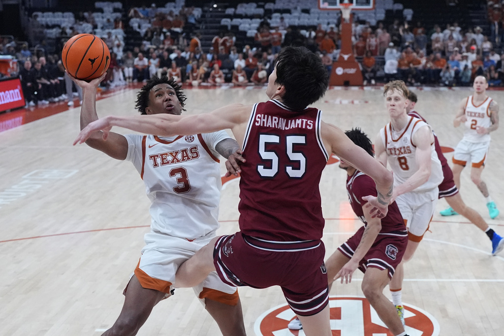 Texas forward Dailyn Swain (3) drives to the basket against South Carolina guard Mike Sharavjamts (55) during the second half of an NCAA college basketball game in Austin, Texas, Feb. 3, 2026. (AP Photo/Eric Gay)