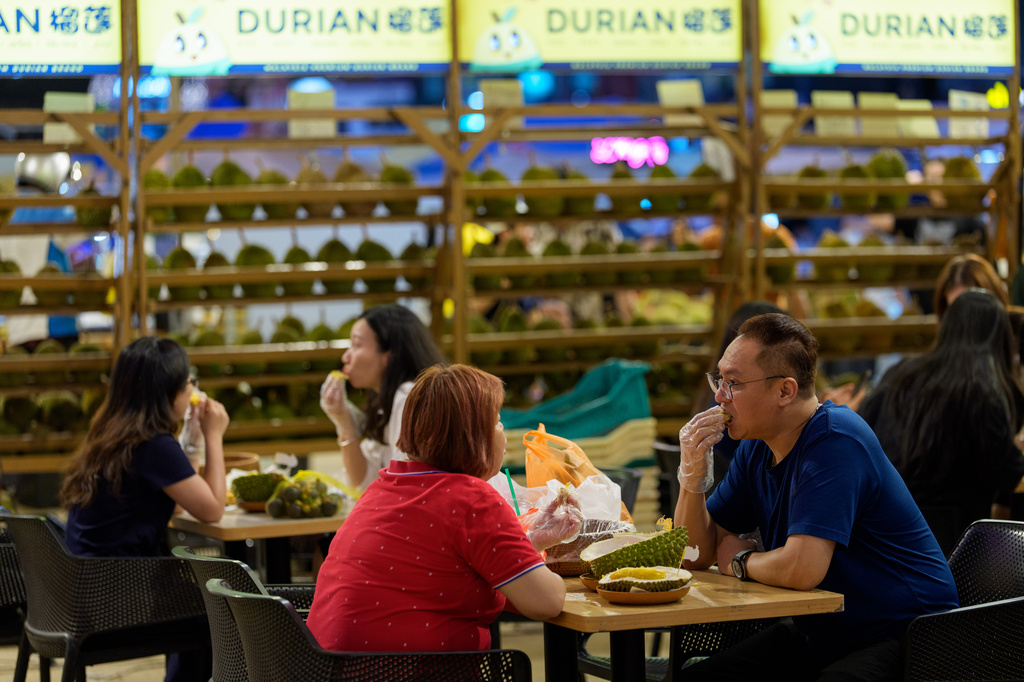Customers eat durian at a durian stall in Petaling Jaya, on the outskirts of Kuala Lumpur, Malaysia, Monday, June 22, 2026. (AP Photo/Vincent Thian)