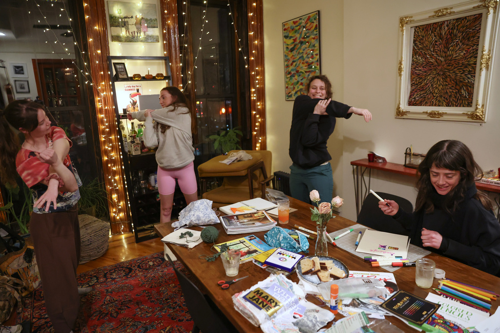 Guests stretch during a weekly phone-free gathering at the home of organizer Dan Fox in the Brooklyn borough of New York, Wednesday, March 25, 2026. (AP Photo/Heather Khalifa)
