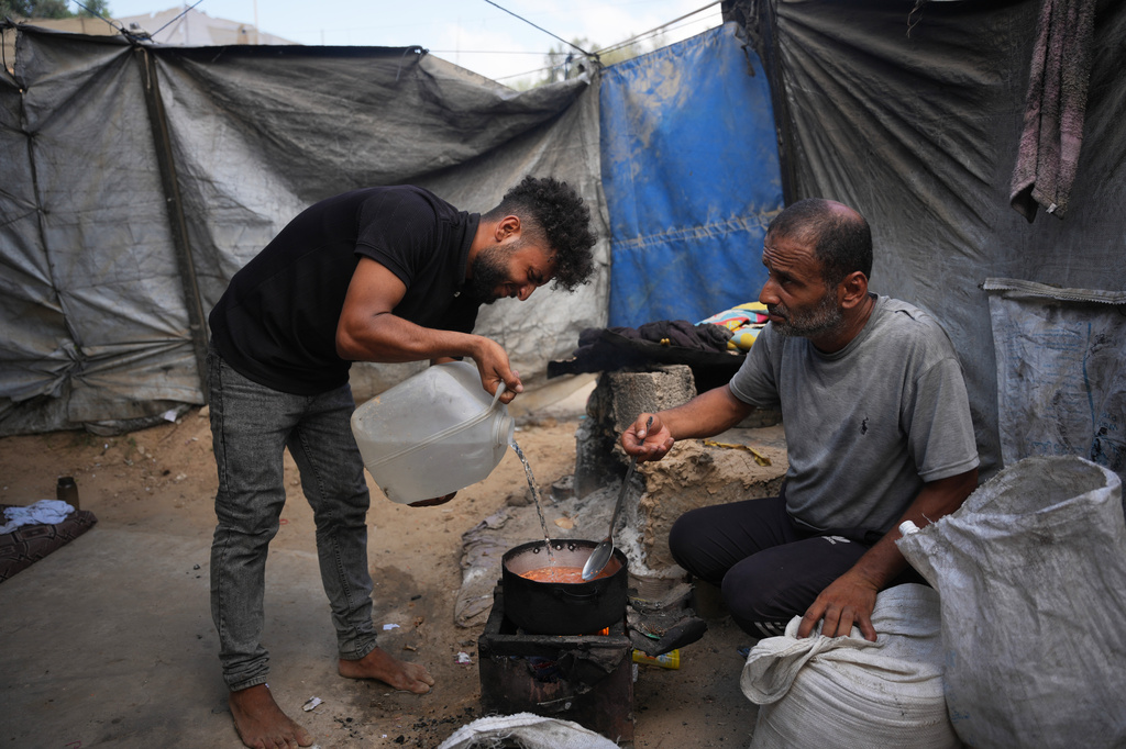 Palestinians use combustible materials collected from a garbage dump as fuel for cooking amid a shortage of cooking gas in Deir al-Balah, central Gaza Strip, Saturday, Aug. 22, 2026. (AP Photo/Abdel Kareem Hana)