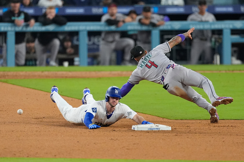 Arizona Diamondbacks second baseman Ketel Marte (4) misses a catch as Los Angeles Dodgers Kyle Tucker (23) slides into second base during the eighth inning of a baseball game Friday, March 27, 2026, in Los Angeles. (AP Photo/Caroline Brehman)