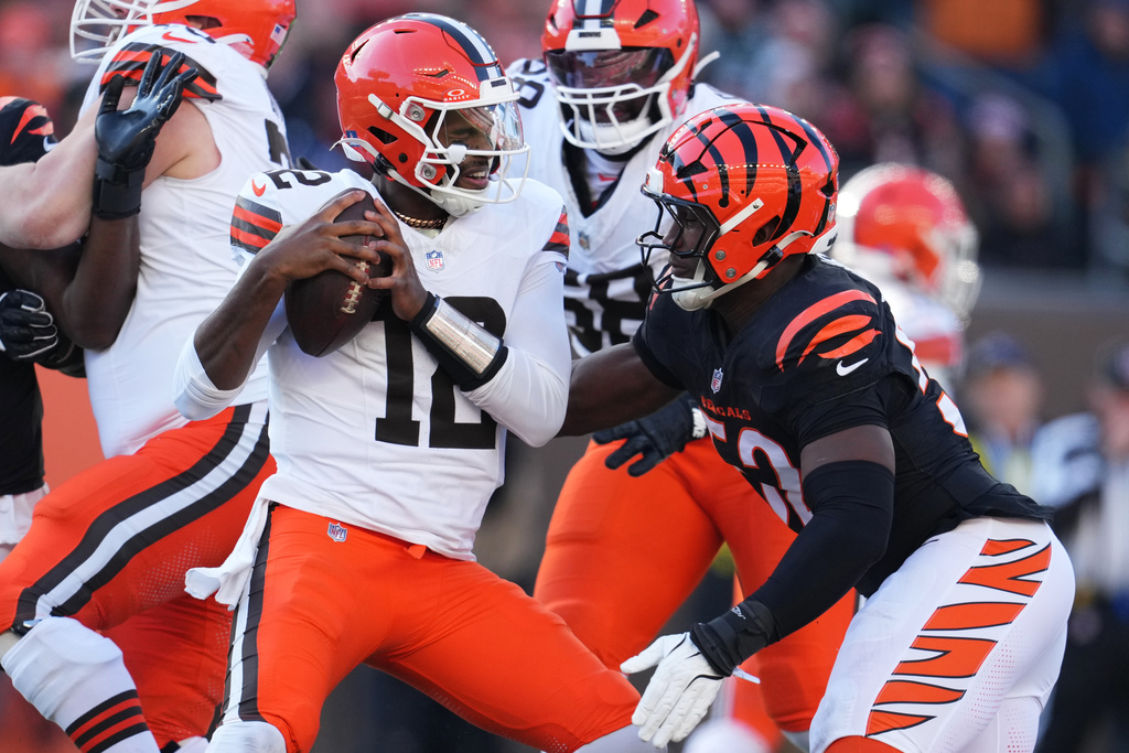 Cincinnati Bengals defensive end Cedric Johnson, right, sacks Cleveland Browns quarterback Shedeur Sanders (12) during the first half of an NFL football game, Sunday, Jan. 4, 2026, in Cincinnati. (AP Photo/Jeff Dean)