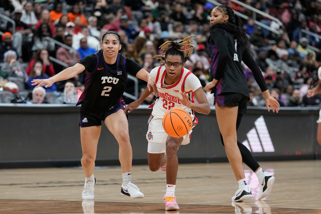 Ohio State's Jaloni Cambridge, center, drives between TCU's Veronica Sheffey, left, and Taylor Bigby during the first half of an NCAA women's college basketball game in Newark, N.J., Monday, Jan. 19, 2026. (AP Photo/Seth Wenig)