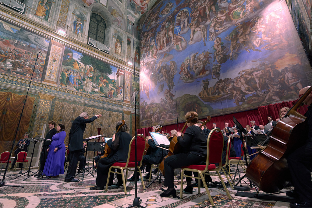 Tenor Matthew McKinney, left, and soprano Elizabeth Watts, second from left, sing Angels Unawares byJames MacMillan, conducted by Harry Christophers, third from left, in the Sistine Chapel at the Vatican, Sunday, March 22, 2026. (AP Photo/Domenico Stinellis)