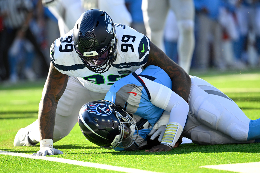 Seattle Seahawks defensive end Leonard Williams (99) sacks Tennessee Titans quarterback Cam Ward (1) during the second half of an NFL football game Sunday, Nov. 23, 2025, in Nashville, Tenn. (AP Photo/John Amis)