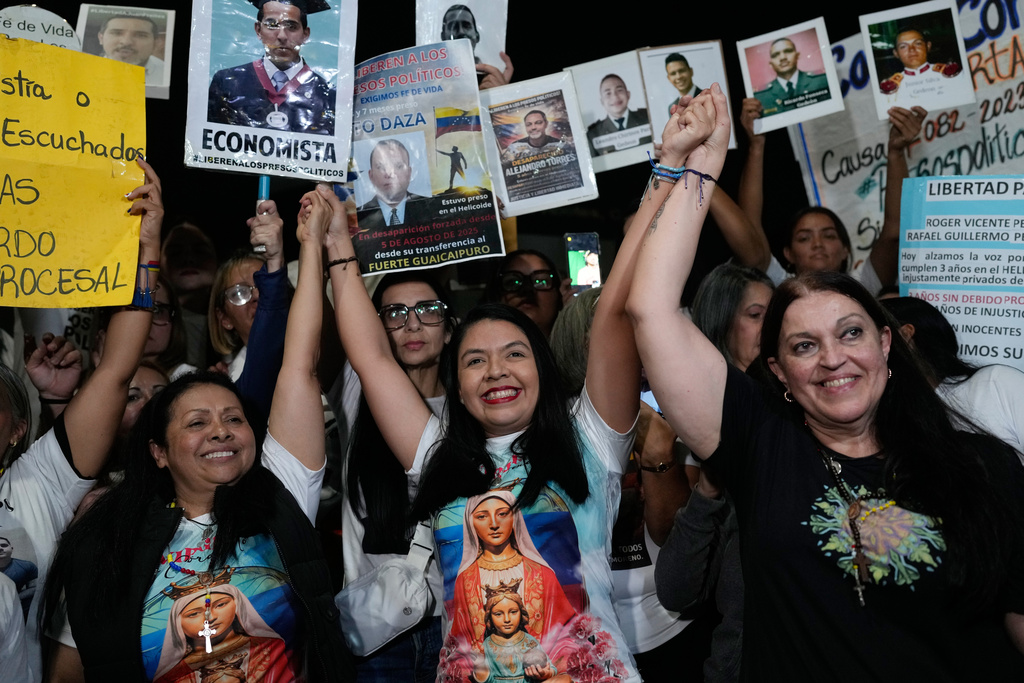 From left, opposition members Dignora Hernández, María Oropeza and Catalina celebrate with supporters after their release from custody near El Helicoide, the Venezuelan intelligence headquarters and detention center, in Caracas, Venezuela, Sunday, Feb. 8, 2026. (AP Photo/Ariana Cubillos)