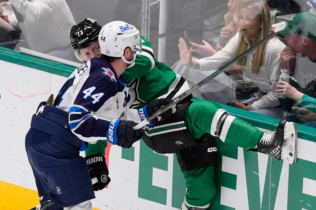 Winnipeg Jets defenseman Josh Morrissey (44) slams Dallas Stars left wing Adam Erne (73) against the boards in the second period of an NHL hockey game Thursday, April 2, 2026, in Dallas. (AP Photo/Tony Gutierrez)