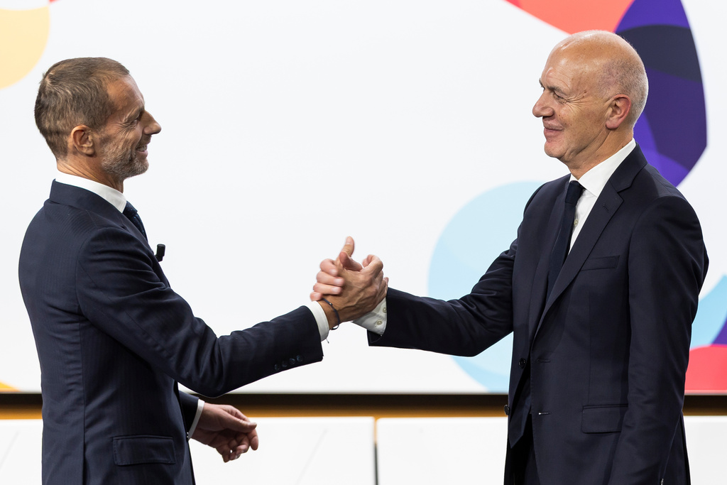 UEFA President Aleksander Ceferin, left, and German Football Association (DFB) president Bernd Neuendorf, right, shake hands during the the announcement ceremony for the host country of the UEFA Women's EURO 2029, in Nyon, Switzerland, Wednesday, Dec. 3, 2025. (Cyril Zingaro/Keystone via AP)