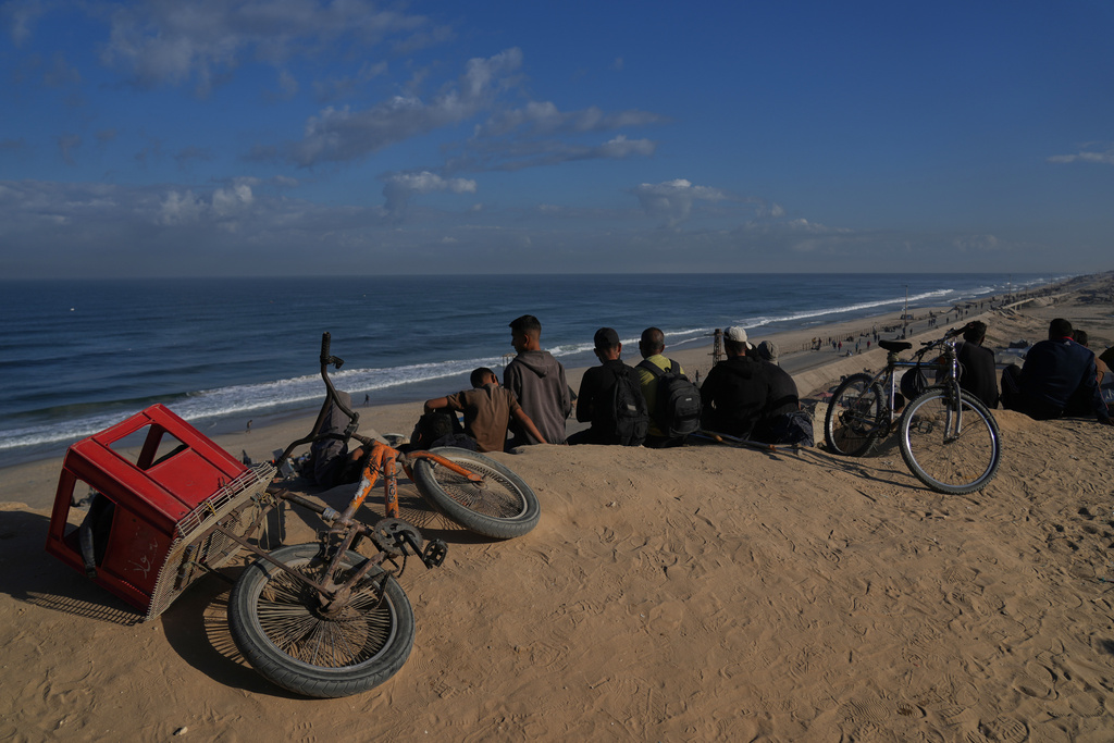 Displaced Palestinians gather on the coastal road near Wadi Gaza in the central Gaza Strip, Friday, Oct. 10, 2025, after Israel and Hamas have agreed to a pause in their war and the release of the remaining hostages. (AP Photo/Abdel Kareem Hana)