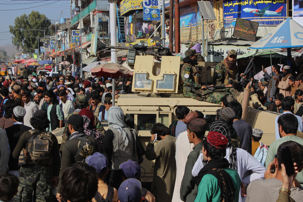 Taliban fighters sit on armored vehicles as residents gather during a protest condemning Pakistan's airstrikes in Afghanistan, in Khost province, Monday, Oct. 13, 2025. (AP Photo/Saifullah Zahir)
